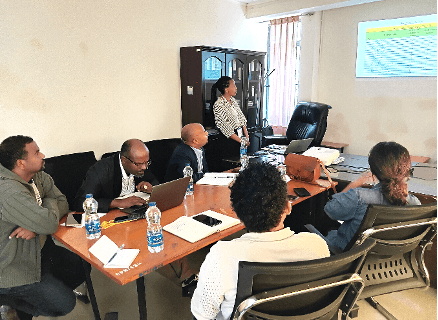 Delegation discussion around a logistics planning table.